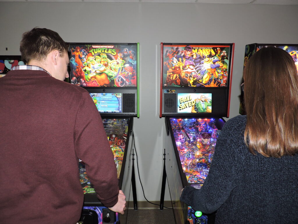 two people playing pinball